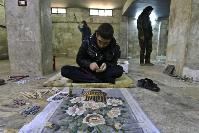 A man works on a mosaic artwork, copied from an original painting, in a workshop in Kafranbel town in the Idlib governorate January 17, 2015. (Photo by Khalil Ashawi/Reuters)