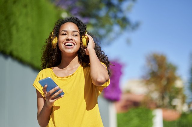 Woman with headphones and smartphone on the street. (Photo by F.J. Jimenez/Getty Images)