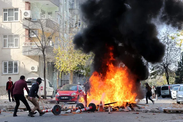 Kurdish protestors clash with Turkish police as they protest against the Turkish government in Diyarbakir, Turkey, 14 December 2015. Residents of the Sur district fled from their houses because of armed clashes between Turkish special forces and PKK militants. According to local media 2 protestors where killed during the protest. (Photo by EPA/Stringer)