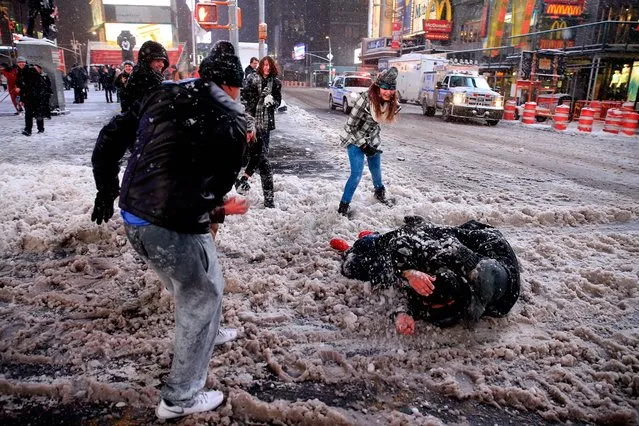 Pedestrians have a snowball fight in Times Square following a mandatory shutdown of the streets at 11 p.m. on January 26, 2015 in New York City. New York, and much of the Northeast, is bracing for a major winter storm which is expected to bring blizzard conditions and 10 to 30 inches of snow to the area. (Photo by Alex Trautwig/AFP Photo)