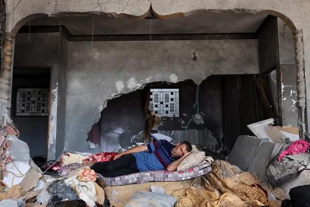 A Palestinian man sleeps in his house, which was heavily damaged during fighting between Israel and Islamic Jihad militants in the beginning of May 2023, in Beit Lahia in the northen Gaza Strip, on May 31, 2023. (Photo by Mohammed Abed/AFP Photo)