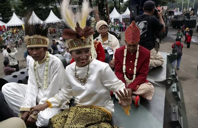 Brides and grooms sit on top of an Indonesian Army vehicle during a mass wedding ceremony organized in Jakarta, Indonesia, Wednesday, January 28, 2015. (Photo by Achmad Ibrahim/AP Photo)