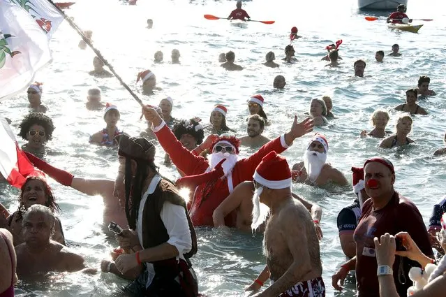 A man dressed as a Santa Claus takes part in the traditional Christmas bath during an unusually warm winter day in Nice, southeastern France, December 20, 2015. (Photo by Eric Gaillard/Reuters)