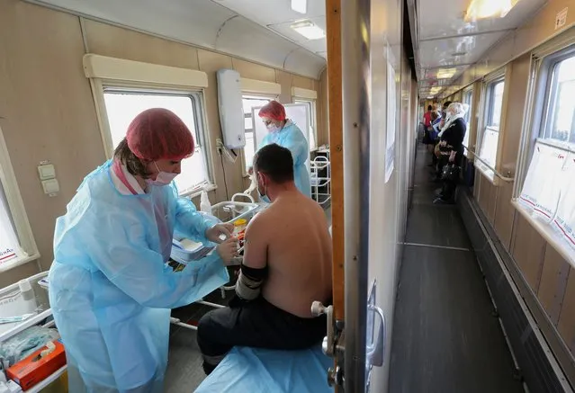 A man receives a dose of Sputnik V (Gam-COVID-Vac) vaccine against the coronavirus in a carriage of the Academician Fyodor Uglov medical train, at a railway station in the town of Tulun in Irkutsk Region, Russia on March 16, 2021. (Photo by Evgeny Kozyrev/Reuters)