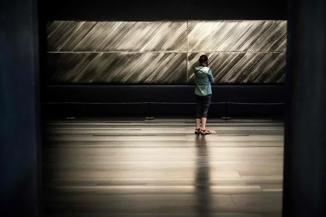 A visitor observes a painting by French artist Pierre Soulages, at the Soulages museum in Rodez, on June 9, 2023. The Pierre Soulages' museum will host, from June 24, 2023 to January 7, 2023, a tribute exhibition devoted to the last 10 years of creation by Pierre Soulages. (Photo by Lionel Bonaventure/AFP Photo)