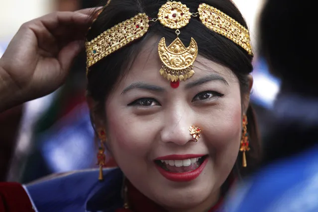 A Nepalese Gurung community woman wearing traditional attire smiles as she participates in a parade to mark the New Year known as “Tamu Loshar” in Kathmandu, Nepal, Wednesday, December 30, 2015. (Photo by Niranjan Shrestha/AP Photo)