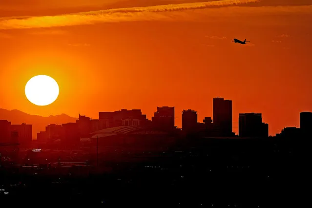A Jet takes flight from Sky Harbor International Airport as the sun sets over downtown Phoenix, Wednesday, July 12, 2023. Millions of people around the Southwest are living through a historic heat wave. Even the heat-experienced desert city of Phoenix is being tested Wednesday as temperatures hit 110 degrees Fahrenheit for more than a dozen consecutive days. Phoenix is currently America's hottest large city with temperatures forecast to hit as high as 119 degrees Fahrenheit over the weekend. (Photo by Matt York/AP Photo)
