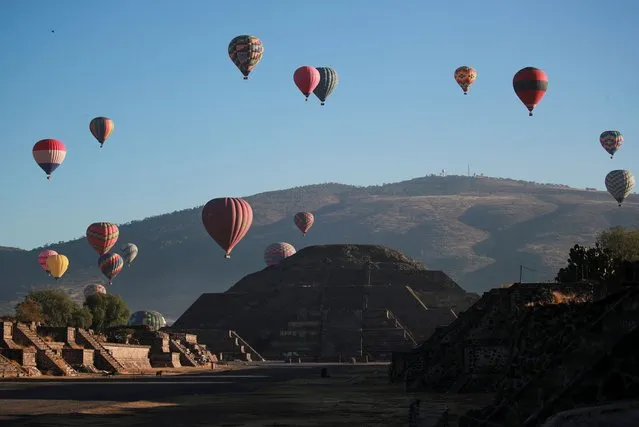The Pyramid of the Moon is seen on the day of the spring equinox as hot air balloons float above the pre-hispanic city of Teotihuacan, on the outskirts of Mexico City, Mexico on March 20, 2023. (Photo by Henry Romero/Reuters)