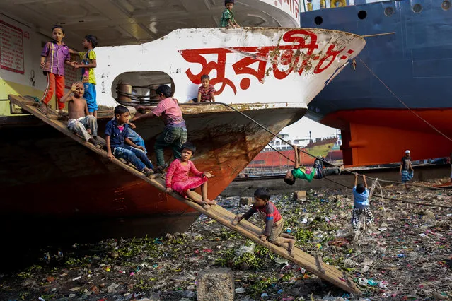Children are playing by the boat in Dhaka, Bangladesh on January 12, 2016. (Photo by Mohammad Ponir Hossain/ZUMA Press/Corbis)