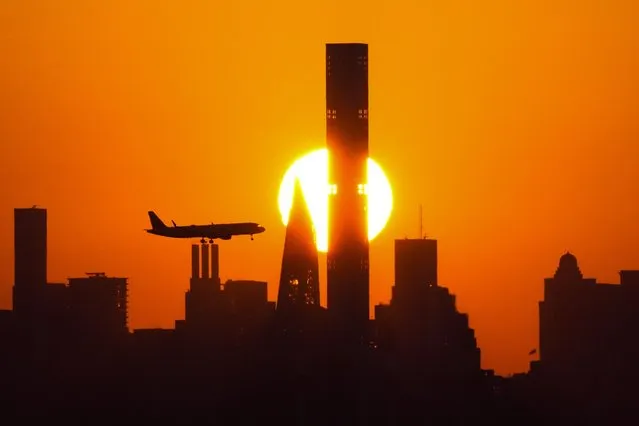 The sun sets behind the Manhattan skyline as plane approaches LaGuardia Airport for a landing before the quarterfinals match between Madison Keys, of the United States, and Marketa Vondrousova, of the Czech Republic, at the U.S. Open tennis championships, Wednesday, September 6, 2023, in New York. (Photo by Frank Franklin II/AP Photo)