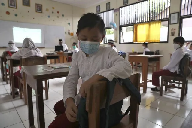 Students wearing face masks sit spaced apart during a trial run of a class with COVID-19 protocols at an elementary school in Jakarta, Indonesia, Friday, June 4, 2021. The world's fourth-most populous country, with about 275 million people, has reported more coronavirus cases than any other Southeast Asian country. (Photo by Tatan Syuflana/AP Photo)