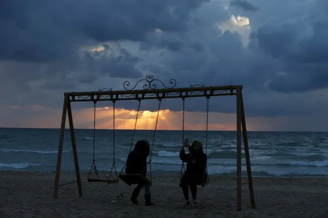 A woman takes a selfie on a swing at the seaside of Ramlet al-Bayda beach as storm clouds loom during sunset in Beirut, Lebanon January 23, 2016. (Photo by Jamal Saidi/Reuters)