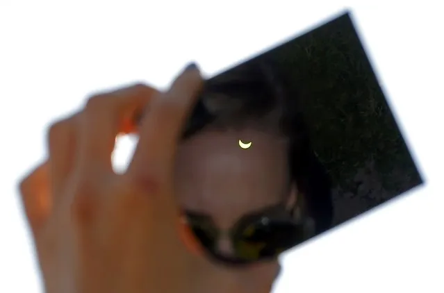 A partial solar eclipse is seen through a dark glass plate in Budapest March 20, 2015. (Photo by Laszlo Balogh/Reuters)