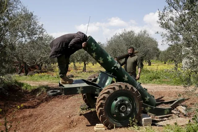 A rebel fighter looks inside a cannon on the frontline of Idlib city in northern Syria March 23, 2015. Picture taken March 23, 2015. (Photo by Khalil Ashawi/Reuters)