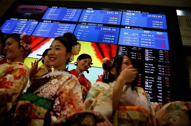 Women, dressed in ceremonial kimonos, pose for pictures in front of an electronic board showing stock prices after the New Year opening ceremony at the Tokyo Stock Exchange (TSE), held to wish for the success of Japan's stock market, in Tokyo, Japan, January 4, 2017. (Photo by Kim Kyung-Hoon/Reuters)