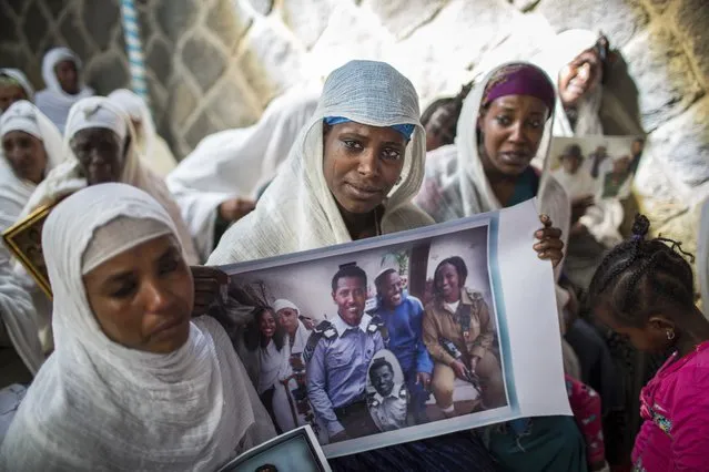 Members of Ethiopia's Jewish community hold pictures of their relatives in Israel, during a solidarity event at the synagogue in Addis Ababa, Ethiopia Wednesday, February 28, 2018. Hundreds of Ethiopian Jews gathered at the synagogue to express concern that Israel's proposed budget removes the funding to help them immigrate to reunite with relatives in that country, as representatives said they will stage a mass hunger strike if Israel eliminates the funding. (Photo by Mulugeta Ayene/AP Photo)