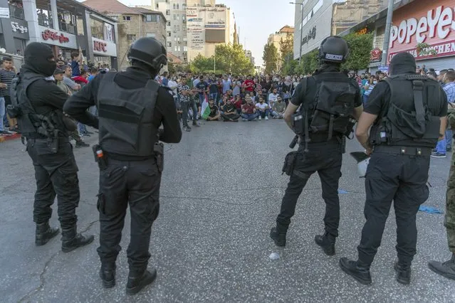 Demonstrators close the road in front of riot police during a rally protesting the death of Palestinian Authority outspoken critic Nizar Banat, in the West Bank city of Ramallah, Saturday, July 3, 2021. Hundreds of Palestinians gathered to demonstrate against President Mahmoud Abbas, hoping to inject new momentum into a protest movement sparked by the death of an outspoken critic in the custody of security forces. (Photo by Nasser Nasser/AP Photo)