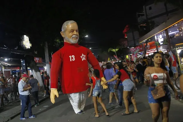 Supporters of Brazil's former President Luiz Inacio Lula da Silva, who is running for office again, attend his campaign rally next to a giant doll of Lula, in Rio de Janeiro, Brazil, Thursday, October 20, 2022. Lula is facing President Jair Bolsonaro in a presidential run-off election set for Oct. 30. (Photo by Bruna Prado/AP Photo)