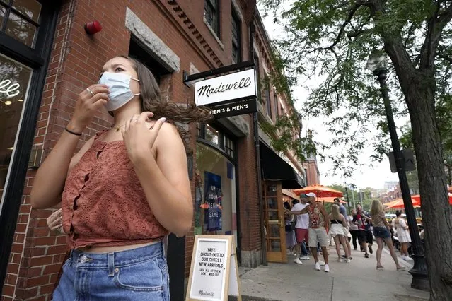 A pedestrian, left, wears a mask out of concern for the coronavirus while walking along Boston's fashionable Newbury Street, Sunday, August 8, 2021. (Photo by Steven Senne/AP Photo)