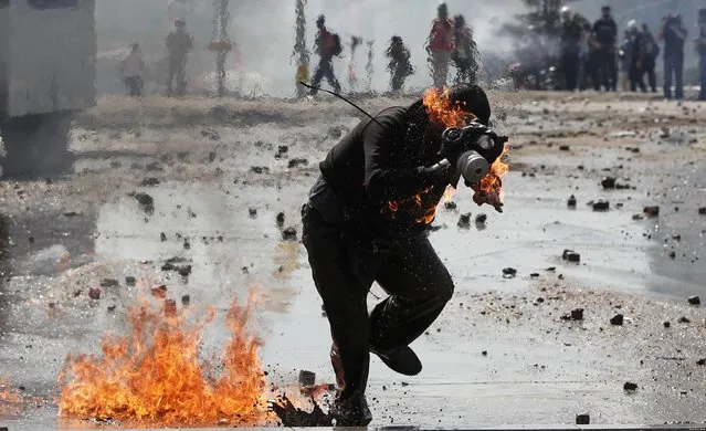 A protestor is on fire after a molotov cocktail goes off during a clash with Turkish riot police at Taksim Square in Istanbul, Turkey, 11 June 2013. (Photo by Sedat Suna/EPA)