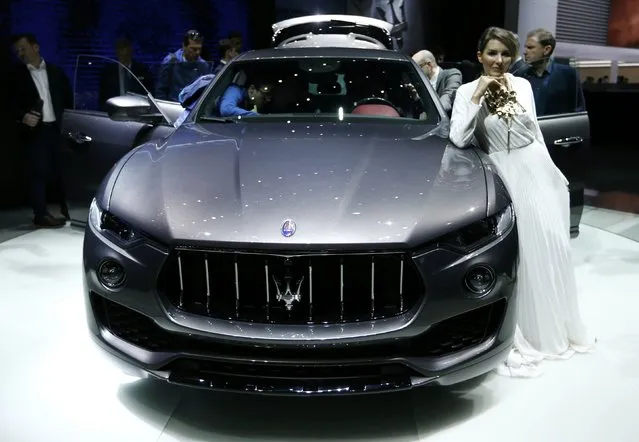 A model leans on a Maserati Levante SUV car at the 86th International Motor Show in Geneva, Switzerland, March 1, 2016. (Photo by Denis Balibouse/Reuters)