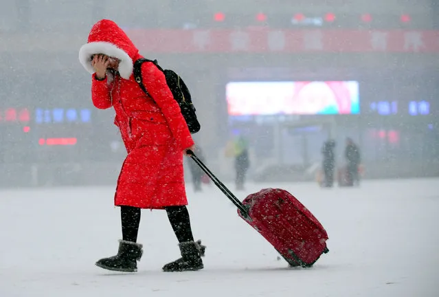 A passenger carries her luggage as she walks in the snow at a railway station in Shenyang, Liaoning province, China January 26, 2017. (Photo by Reuters/Stringer)