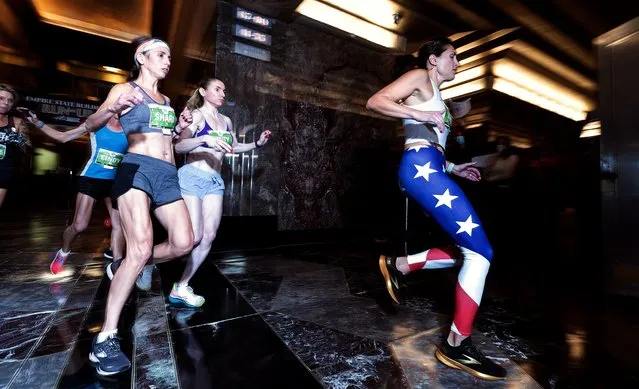 Runners in the women's elite division heat race to the first stairs just off the starting line of the 43rd Annual Empire State Building Run-Up in New York, New York, USA, 26 October 2021. Runners in the annual race climb 86 floors, 1,576 steps, from the lobby to the 86th floor observation deck. (Photo by Justin Lane/EPA/EFE)