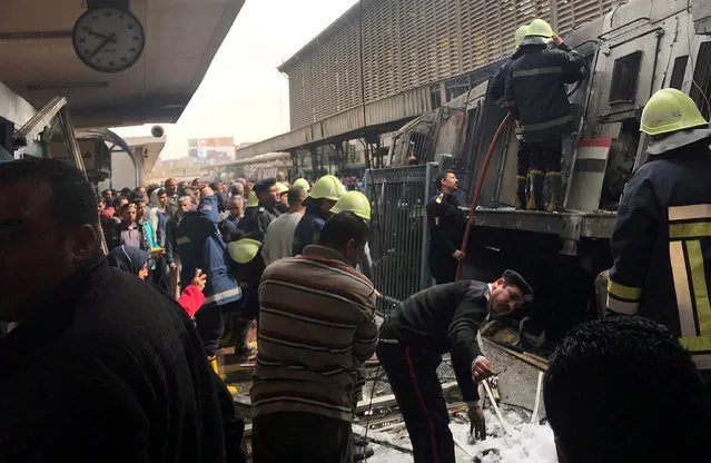 A member of security forces gestures as rescue workers and people gather at the scene after a fire caused deaths and injuries at the main train station in Cairo, Egypt, February 27, 2019. (Photo by Amr Abdallah Dalsh/Reuters)