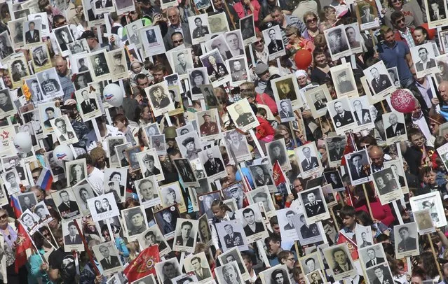 People hold pictures of World War Two soldiers as they take part in the Immortal Regiment march during the Victory Day celebrations in Barnaul, Russia, May 9, 2015. (Photo by Andrei Kasprishin/Reuters)