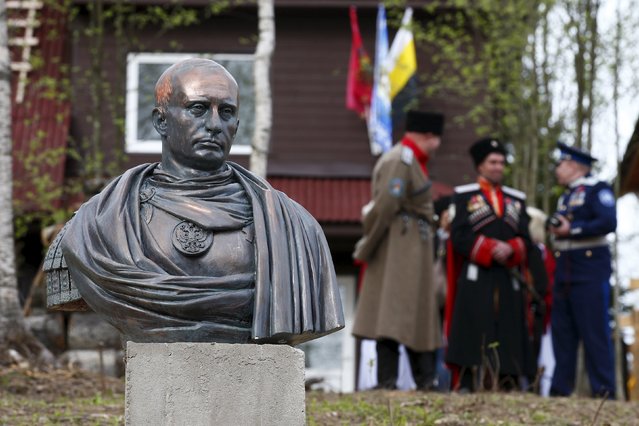 Cossacks stand behind a bust of Russian President Vladimir Putin which depicts him as a Roman emperor, during its unveiling ceremony in Leningrad region, Russia, May 16, 2015. (Photo by Maxim Zmeyev/Reuters)