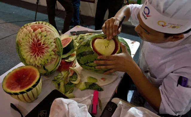 An Indian chef carves a watermelon during a fruit and vegetable carving compitition at “Culinary Art India 2014” at Pragati Maidan in New Delhi on March 10, 2014. “Culinary Art India 2014” is organized by Indian Culinary Forum in association with ITPO and Hospitality First. This event will see coming together of 250 chefs under one roof and exhibiting their culinary skills to the masses. (Photo by Prakash Singh/AFP Photo)