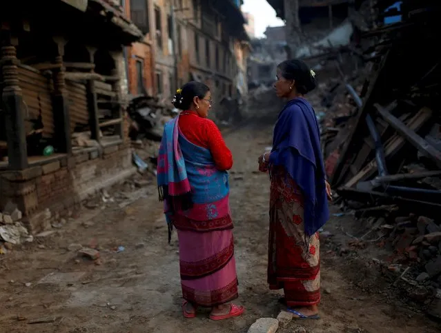 Women chat as they stand next to collapsed houses in the early morning hours in Bhaktapur near Kathmandu, Nepal, May 14, 2015. (Photo by Ahmad Masood/Reuters)