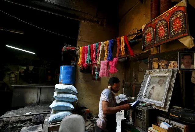 Hisham Aly, 37, takes an order on the phone at a dye workshop in old Cairo, Egypt, March 17, 2016. (Photo by Amr Abdallah Dalsh/Reuters)