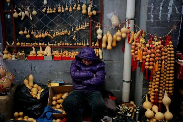 A vendor takes a nap at his stall with calabash products at the Shilihe Tianjiao Cultural Products Market in Beijing, China, 26 February 2017. The market is famous for offering birds, flower, fish and insect but also Chinese craftwork. The popular market is set to close in March 2017 due to new urban planning and the relocate non-capital functions out of the densely populated city center. Beijing's new mayor Cai Qi has vowed to cut the city off all functions unrelated to its status as national capital, in an effort to push the growing population into the surrounding provinces. (Photo by Wu Hong/EPA)