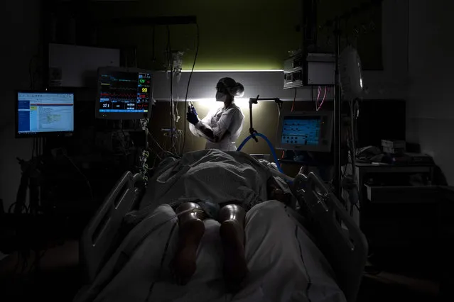 A nurse takes care of a patient infected with Covid 19, on January 25, 2021 in the intensive care unit of Lyon-Sud hospital in Pierre-Benite. Stubbornly high new rates for infections, hospitalisations and Covid deaths fuelled fears France may need another full lockdown, which would be the third, inflicting yet more devastation on businesses and daily lives. The president of the scientific council set up to advise the government on the pandemic pleaded on January 24, 2021 for a swift decision. (Photo by Jeff Pachoud/AFP Photo)