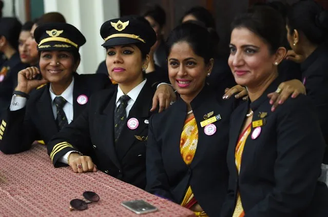 Indian women pilots from Air India pose for a photograph during an event on the eve of International Women's Day in New Delhi on March 7, 2017. A non-stop all-women flight from Delhi to San Franscisco travelled via the Pacific Ocean and returned via the Atlantic Ocean, completing a round trip of the world with 16 crew members and 250 passengers on-board. (Photo by Money Sharma/AFP Photo)