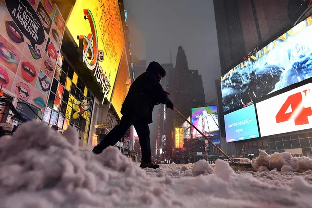 A man plows snow from a street at the Times Square in New York on March 14, 2017. (Photo by Jewel Samad/AFP Photo)