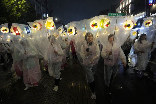 Buddhists participate in a lantern parade, wrapped in plastic sheets to protect from the rain, during the Lotus Lantern Festival, ahead of the birthday of Buddha at Dongguk University in Seoul, South Korea, Saturday, May 11, 2024. (Photo by Ahn Young-joon/AP Photo)