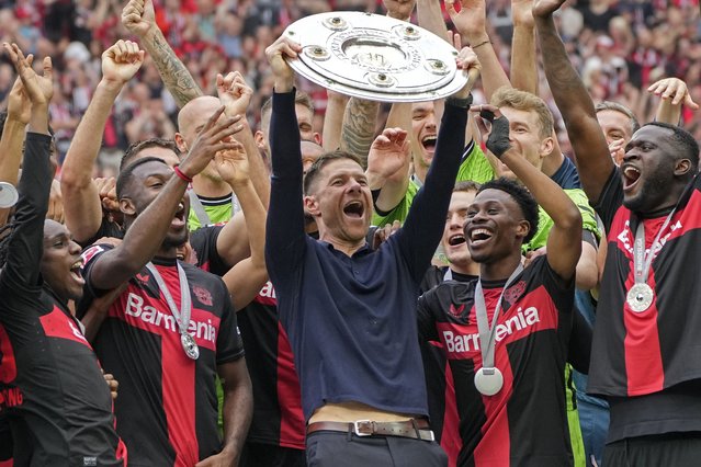 Leverkusen's head coach Xabi Alonso celebrates with the trophy as his team won the German Bundesliga, after the German Bundesliga soccer match between Bayer Leverkusen and FC Augsburg at the BayArena in Leverkusen, Germany, Saturday, May 18, 2024. Bayer Leverkusen have won the Bundesliga title for the first time. It is the first team in Bundesliga history, that won the championship unbeaten for the whole season. (Photo by Martin Meissner/AP Photo)