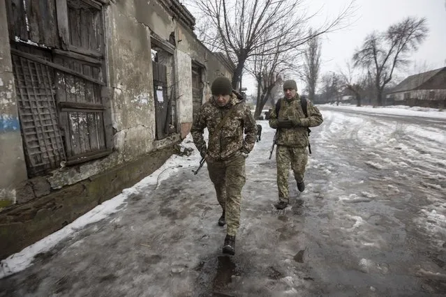 Ukrainian servicemen walk on a road at the line of separation in the Luhansk region, in Luhansk, Ukraine, Thursday, February 3, 2022. When the U.S. and NATO rejected the Kremlin's security demands over Ukraine last week, fears of an imminent Russian attack against its neighbor soared. (Photo by Andriy Dubchak/AP Photo)