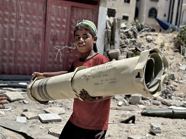 Palestinian boy carries empty or unexploded US-manufactured ammunition and the remnants of rockets which were found in the region after Israeli army's withdrawal from Khan Yunis, Gaza on June 04, 2024. The Israeli army used numerous US-made munitions during its ground operation in the city of Khan Yunis in the Gaza Strip in recent months. (Photo by Doaa Albaz/Anadolu via Getty Images)