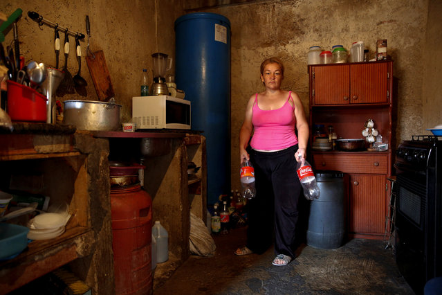 Yunni Perez holds plastic bottles used to carry water while she poses for a picture in her house, in a neighbourhood called “The Tank” at the slum of Petare in Caracas, Venezuela, April 3, 2016. (Photo by Carlos Garcia Rawlins/Reuters)