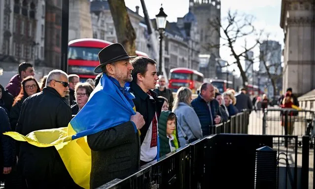 Two men draped in a Ukrainian flag stand outside the gates of Downing Street the residence of the UK Prime Minister Boris Johnson on February 25, 2022 in London, England. Overnight, Russia began a large-scale attack on Ukraine, with explosions reported in multiple cities and far outside the restive eastern regions held by Russian-backed rebels. European governments reacted with widespread condemnation and vows of more sanctions. (Photo by Jeff J. Mitchell/Getty Images)