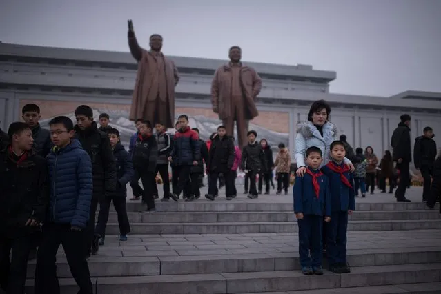 A woman and two children pose for a photo as they visit the statues of late North Korean leaders Kim Il-Sung and Kim Jong-Il to pay their respects on the occasion of the 75th anniversary of the birth of Kim Jong-Il, at Mansudae hill in Pyongyang on February 16, 2017. (Photo by Ed Jones/AFP Photo)