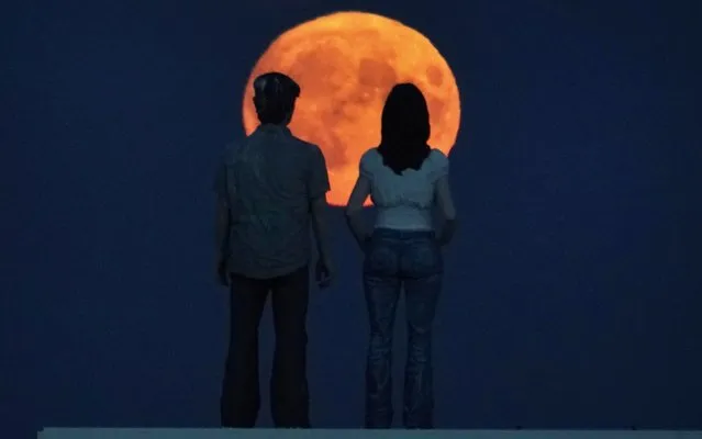 A Harvest full moon, which occurs just before the Autumn Equinox, signaling the start of a new season, rises at the sculpture of the “Couple” by artist Sean Henry at Newbiggin-by-the-Sea in Northumberland, North East England on September 13, 2019. (Photo by Owen Humphreys/PA Images via Getty Images)