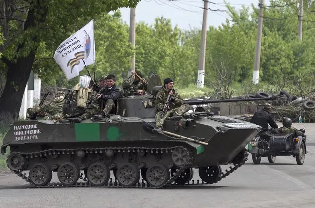 Pro-Russian armed men ride on top of an armoured personnel carrier near the town of Slaviansk, eastern Ukraine, May 5, 2014. Pro-Russian separatists ambushed Ukrainian forces on Monday, triggering heavy fighting on the outskirts of the rebel stronghold of Slaviansk, Interior Minister Arsen Avakov was quoted as saying. (Photo by Baz Ratner/Reuters)