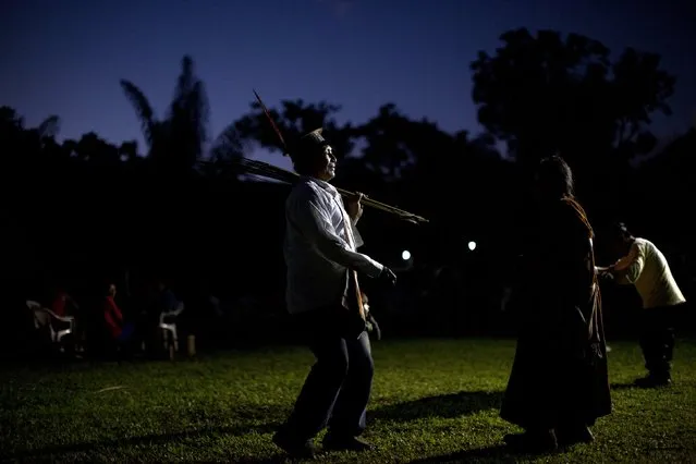 In this June 23, 2015 photo, an Ashaninka Indian man rests his bow and arrows on his left shoulder, as he dances during the 44th anniversary celebrations of their village, Otari Nativo, Pichari, Peru. The annual festivities marking the founding of the Ashaninka community of Otari Nativo with activities that include a beauty pageant, an archery competition, the fastest petate or bedroll weaver challenge, as well as a drinking contest for imbibing the fermented juice of the cassava root, known locally as masato. (Photo by Rodrigo Abd/AP Photo)