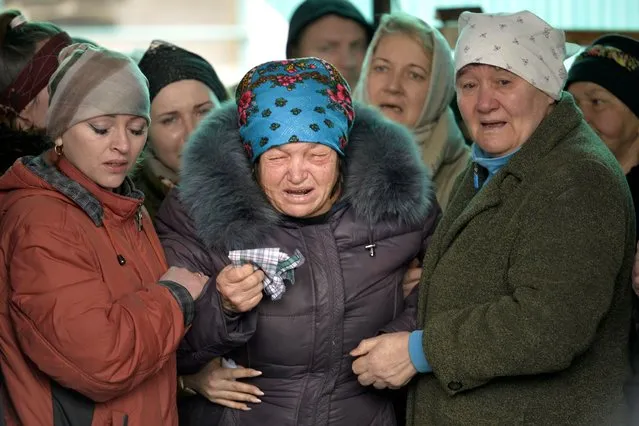 The mother of Russian Army soldier Rustam Zarifulin, who was killed fighting in Ukraine, center, cries surrounded by relatives during a farewell ceremony in his homeland in Kara-Balta, 60 km (37 miles) west of Bishkek, Kyrgyzstan, Sunday, March 27, 2022. (Photo by Vladimir Voronin/AP Photo)