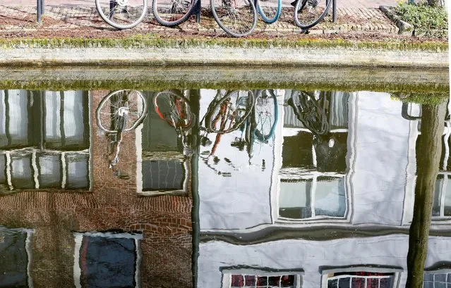 Bicycles are seen reflected in the water of a canal in Delft, Netherlands March 14, 2017. (Photo by Yves Herman/Reuters)