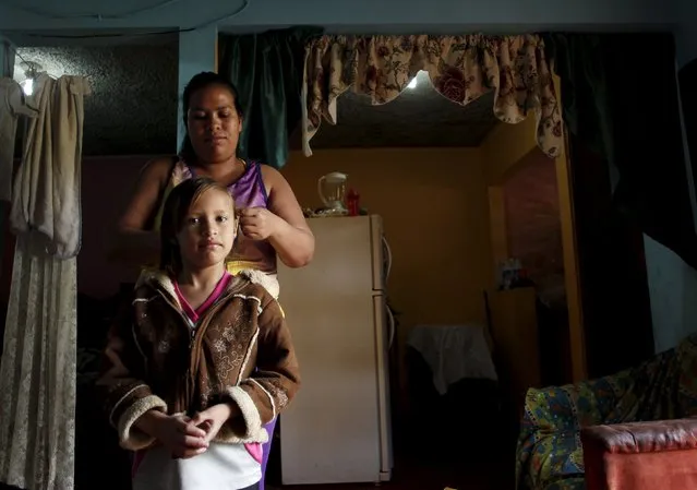 Hazel Castillo combs her daughter Tyra Jaen's hair, at home before going to an aerobics class in Los Guidos de Desamparados July 23, 2015. (Photo by Juan Carlos Ulate/Reuters)